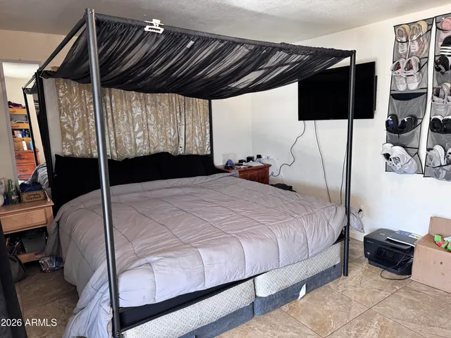 a bedroom with a bed and a flat tv screen