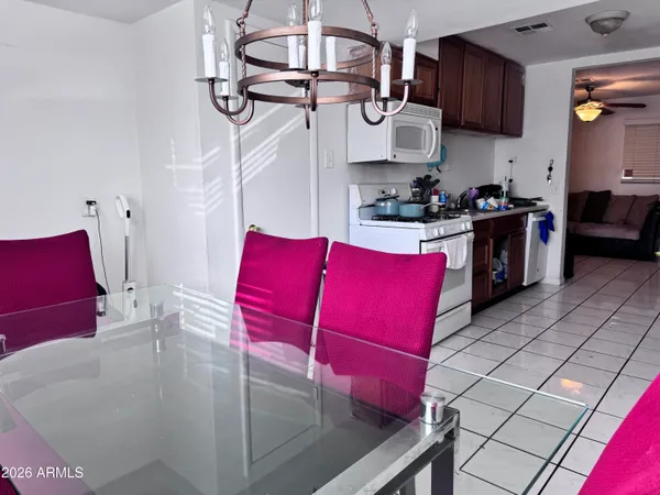 a kitchen with stainless steel appliances kitchen island granite countertop a table chairs in it and wooden floors