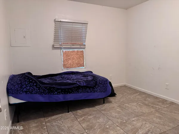 a bed sitting in a bedroom next to a window