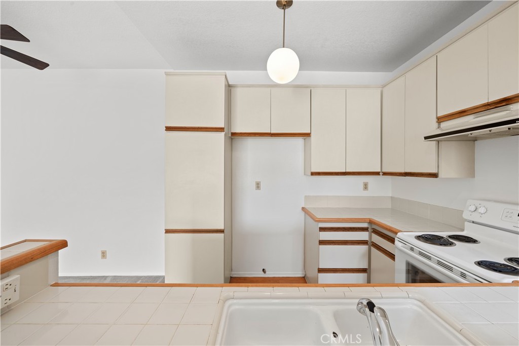 27645 Susan Beth Way, Unit A Saugus, CA 91350 - Photo 12 of 26 a kitchen with stainless steel appliances granite countertop a sink and a refrigerator