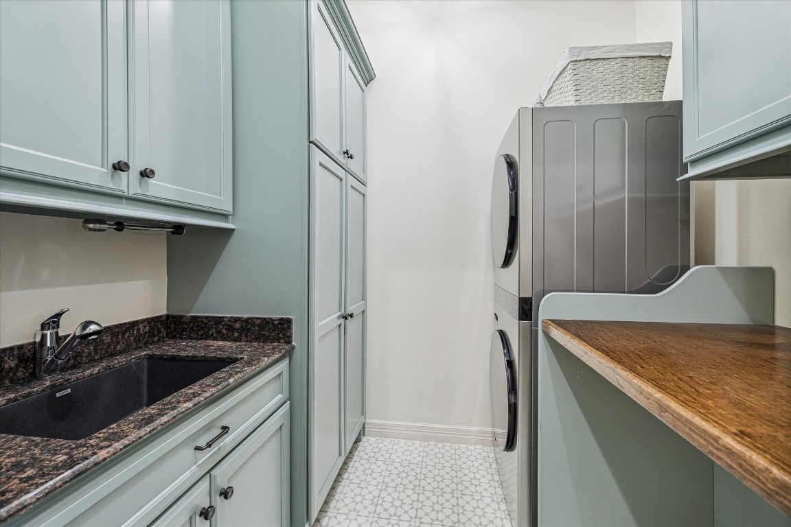 3810 Drake Street Houston, TX 77005 - Photo 33 of 48 LAUNDRY. A part of the 50k worth of upgrades the current owners put into the home, with aloe green cabinets, new tile flooring, LG washtower and wooden folding bench, its a laundry you might actually like doing the laundry in.