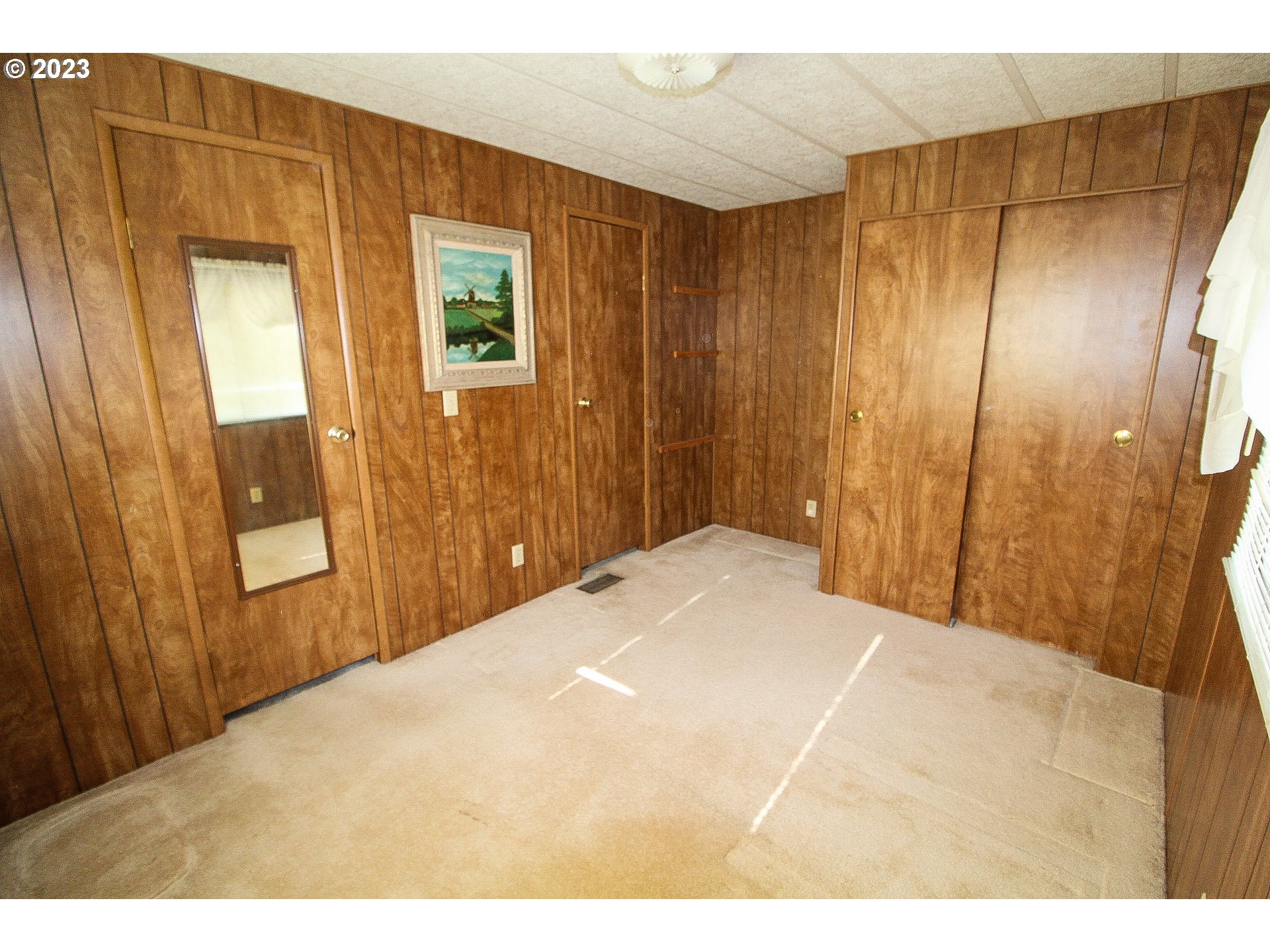 1400 Candlelight Drive, Unit 160 Eugene, OR 97402 - Photo 16 of 31 a bedroom with a bed and a mirror