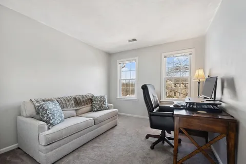 a livingroom with workspace couch and a window