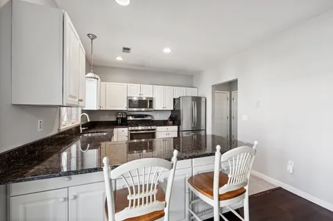 a kitchen with stainless steel appliances kitchen island granite countertop a refrigerator and microwave