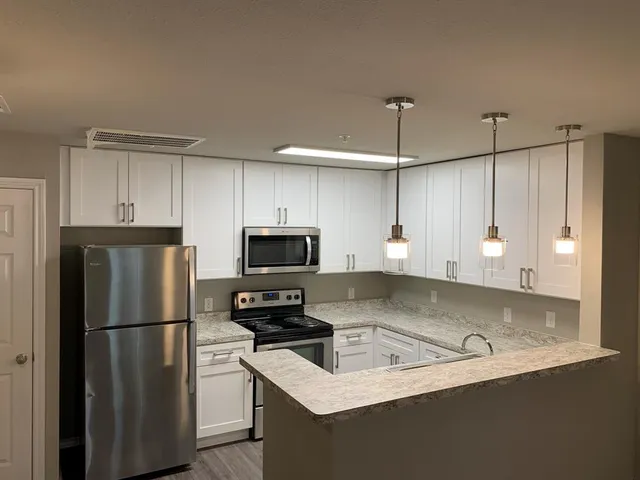 a kitchen with kitchen island a counter appliances and a cabinets