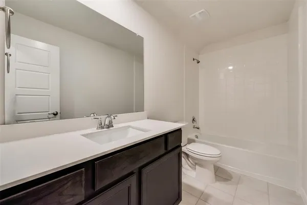 a bathroom with a sink a toilet a mirror and shower