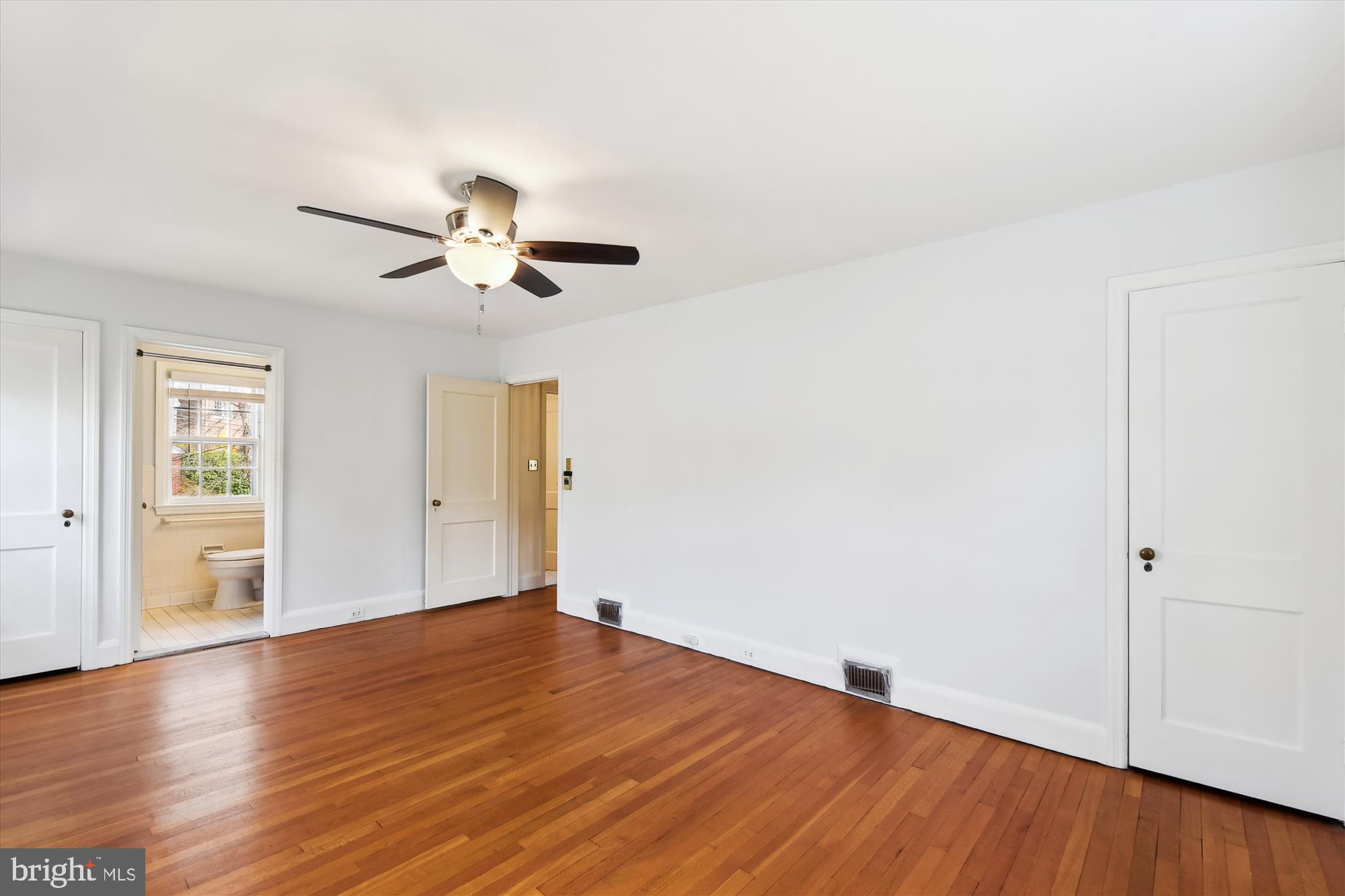 5433 Springlake Way Baltimore, MD 21212 - Photo 24 of 58 an empty room with wooden floor chandelier fan and windows