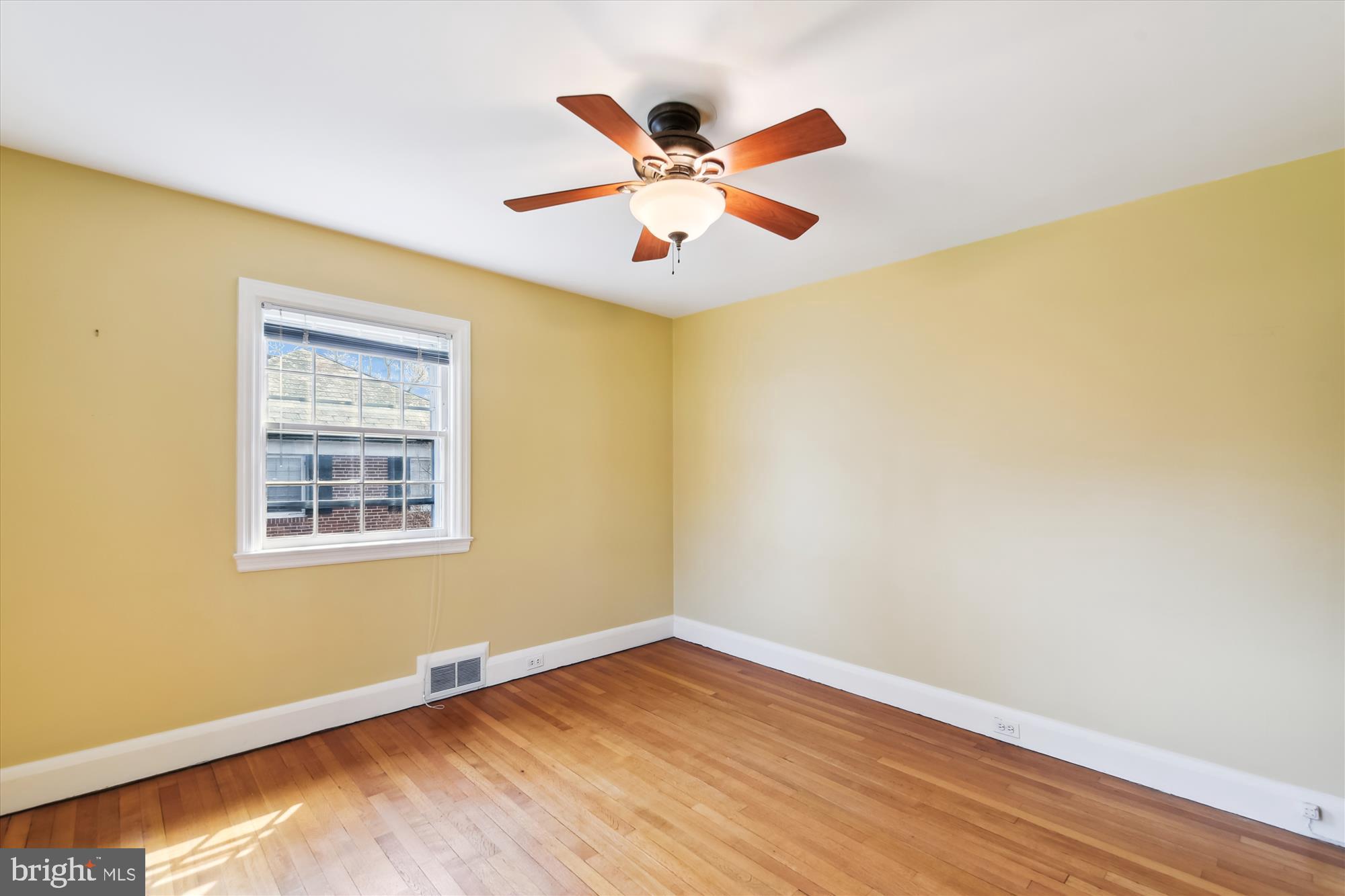 5433 Springlake Way Baltimore, MD 21212 - Photo 36 of 58 a view of an empty room with wooden floor and a ceiling fan