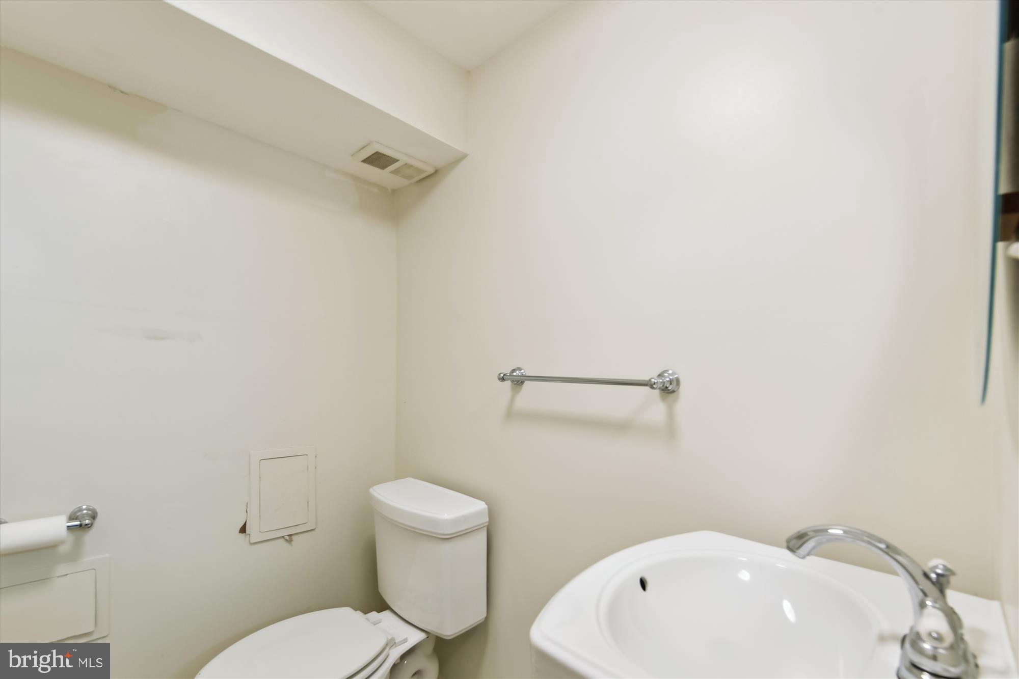 5433 Springlake Way Baltimore, MD 21212 - Photo 43 of 58 a white toilet sitting next to a white sink and vanity