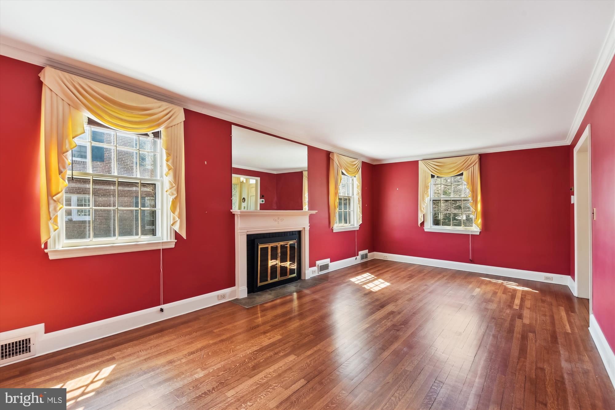 5433 Springlake Way Baltimore, MD 21212 - Photo 7 of 58 an empty room with windows fireplace and wooden floor