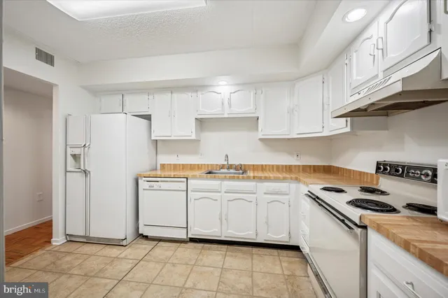 a kitchen with cabinets stainless steel appliances and a sink