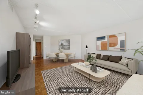 a living room with furniture a lamp and a flat screen tv