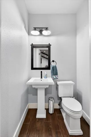 a bathroom with a toilet a sink and mirror