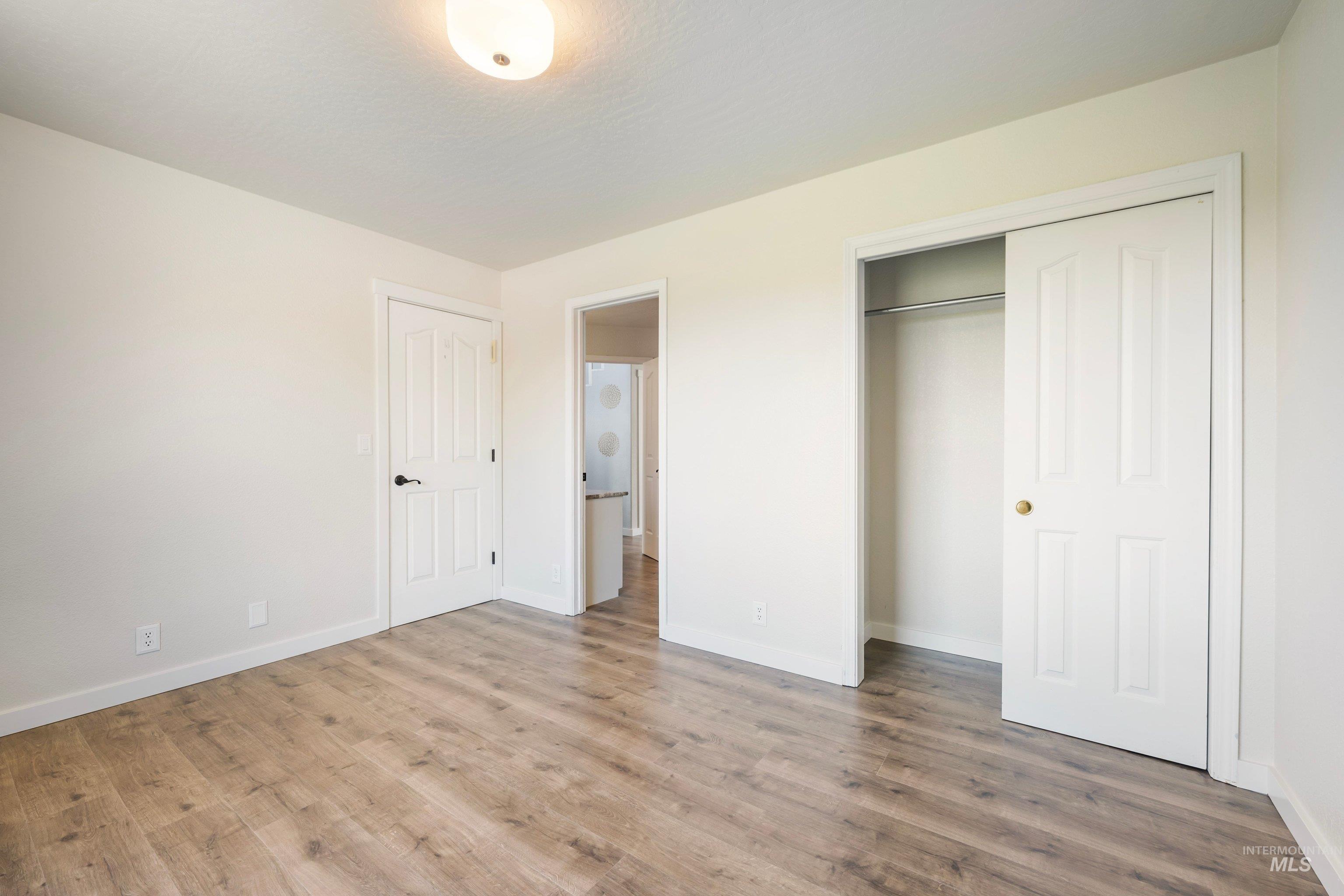 7657 Track Road Nampa, ID 83686 - Photo 18 of 49 Spacious room featuring wood-finish flooring, white baseboards, and a neutral wall color