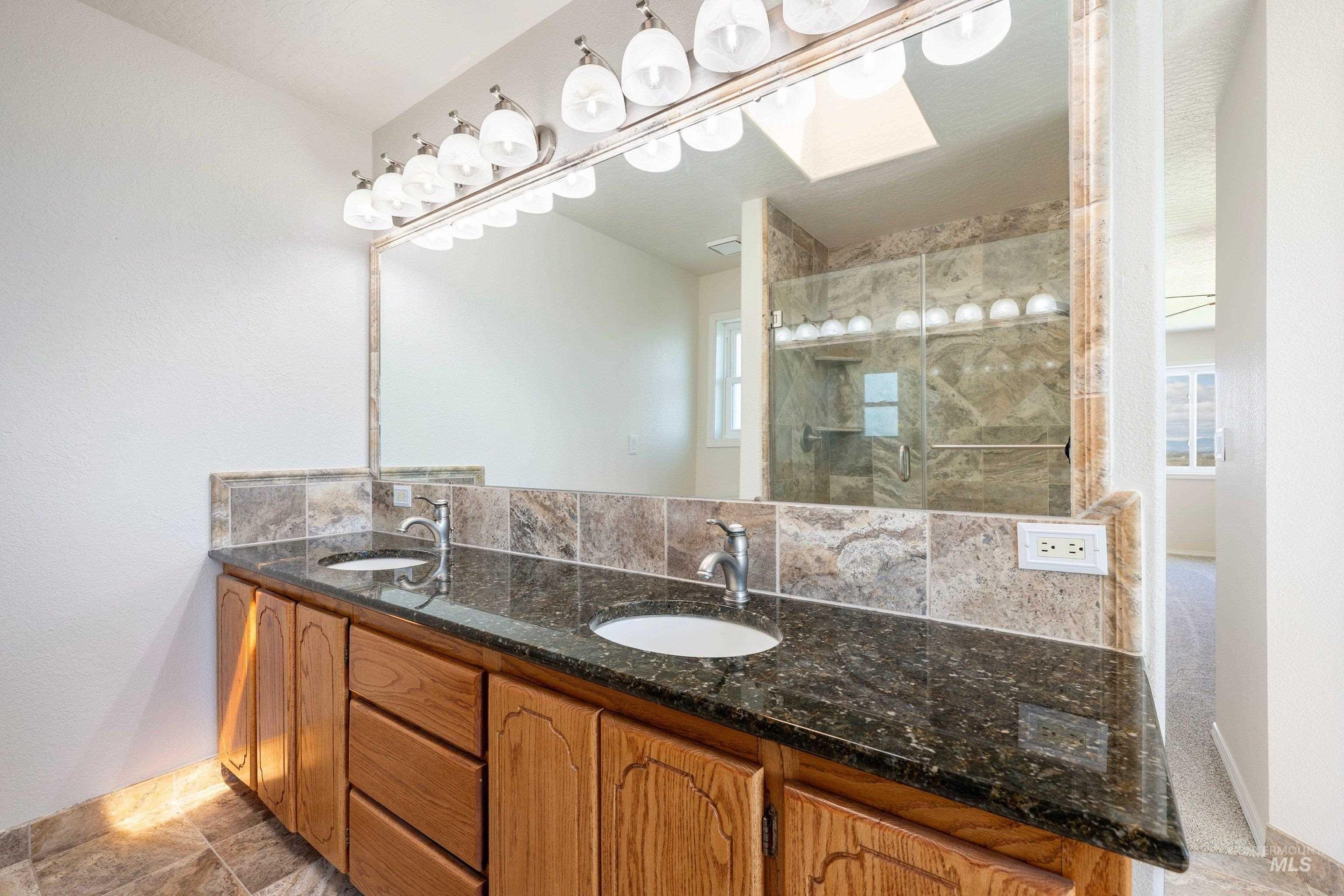 7657 Track Road Nampa, ID 83686 - Photo 25 of 49 Dual vanity with dark stone countertop and integrated sinks