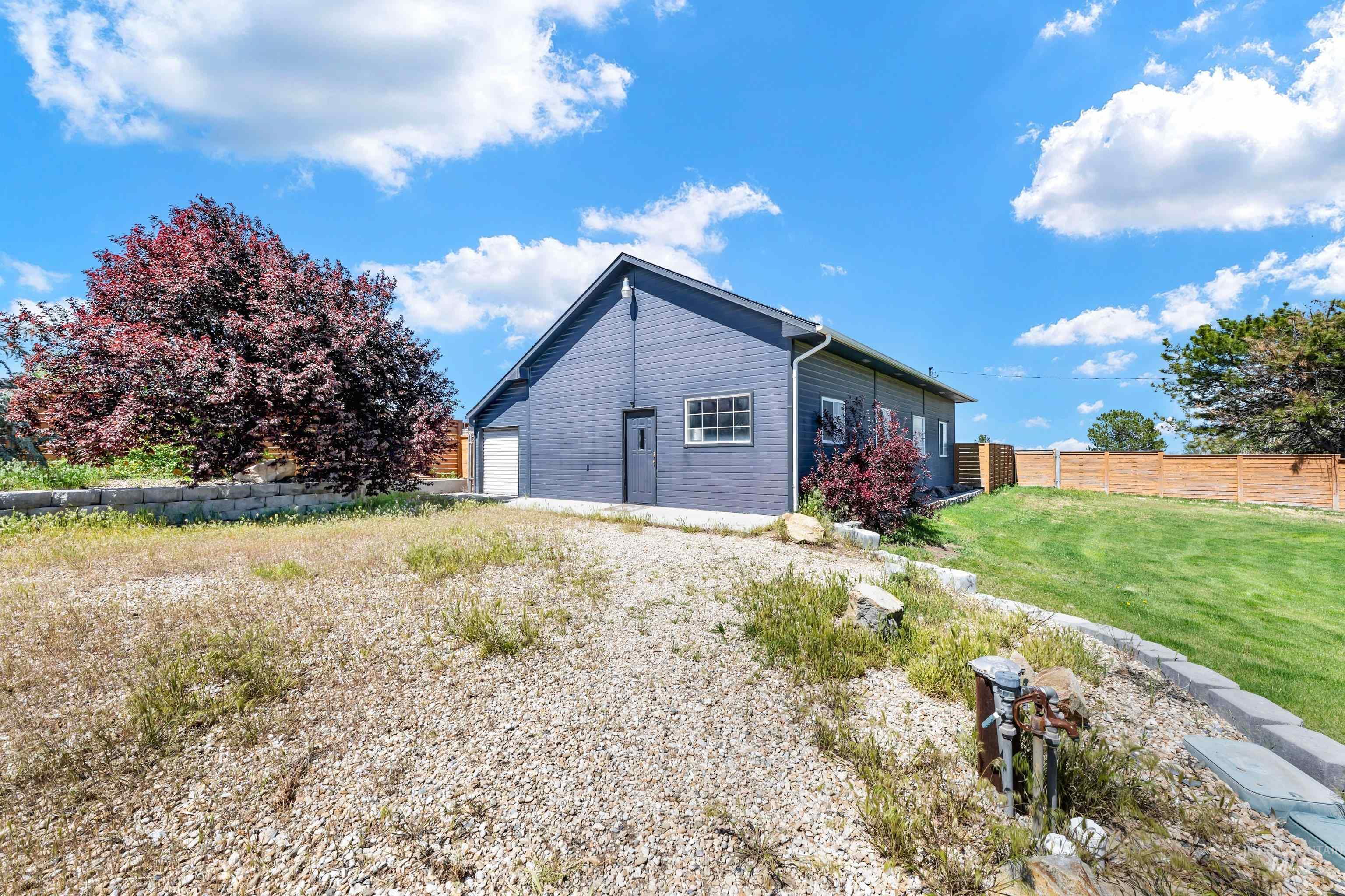 7657 Track Road Nampa, ID 83686 - Photo 33 of 49 Exterior featuring gray siding, white trim, a single garage door, and a separate entry door