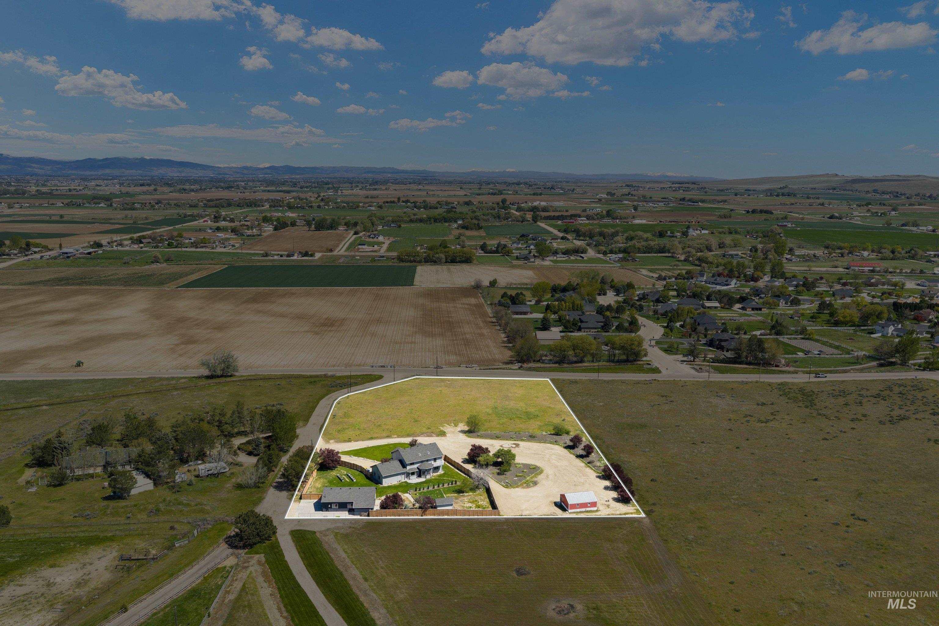 7657 Track Road Nampa, ID 83686 - Photo 41 of 49 Aerial view of a residential property featuring a main dwelling, a detached structure, a manicured lawn, and mature landscaping
