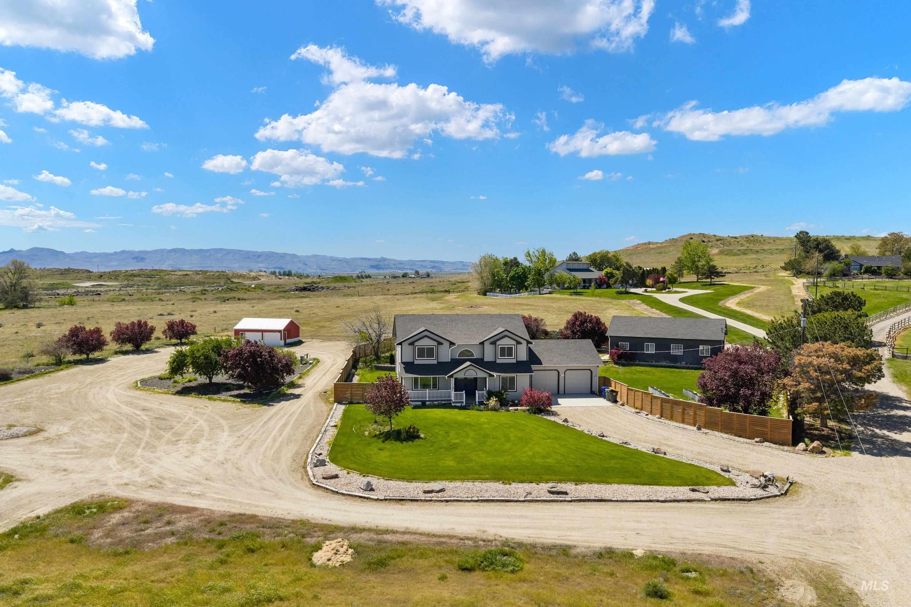 7657 Track Road Nampa, ID 83686 - Photo 46 of 49 Spacious property featuring a two-story residence with an attached garage, a separate outbuilding, and a red barn