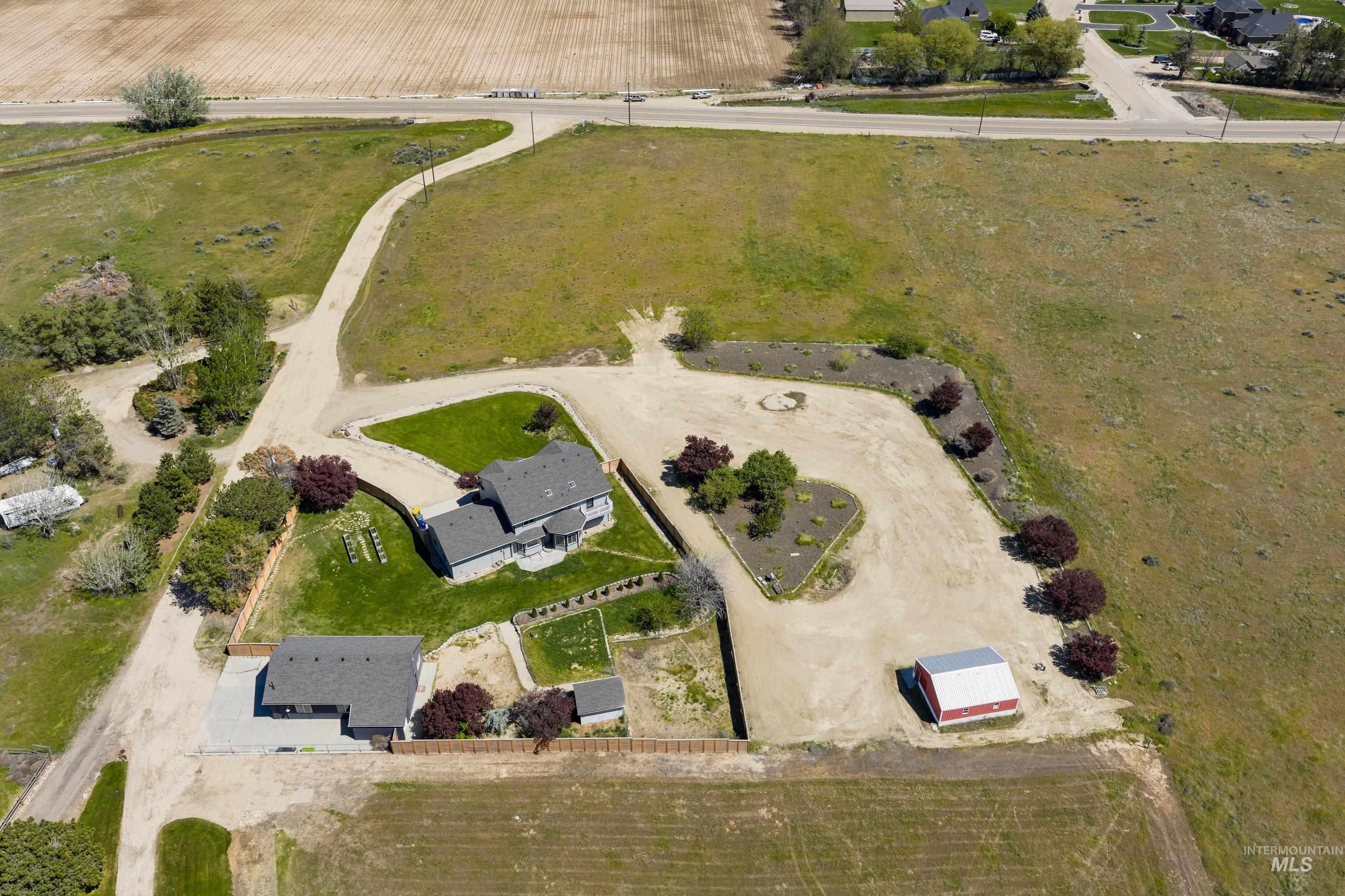 7657 Track Road Nampa, ID 83686 - Photo 47 of 49 Expansive property featuring two residential structures, a detached red barn with a metal roof, and a gravel driveway system
