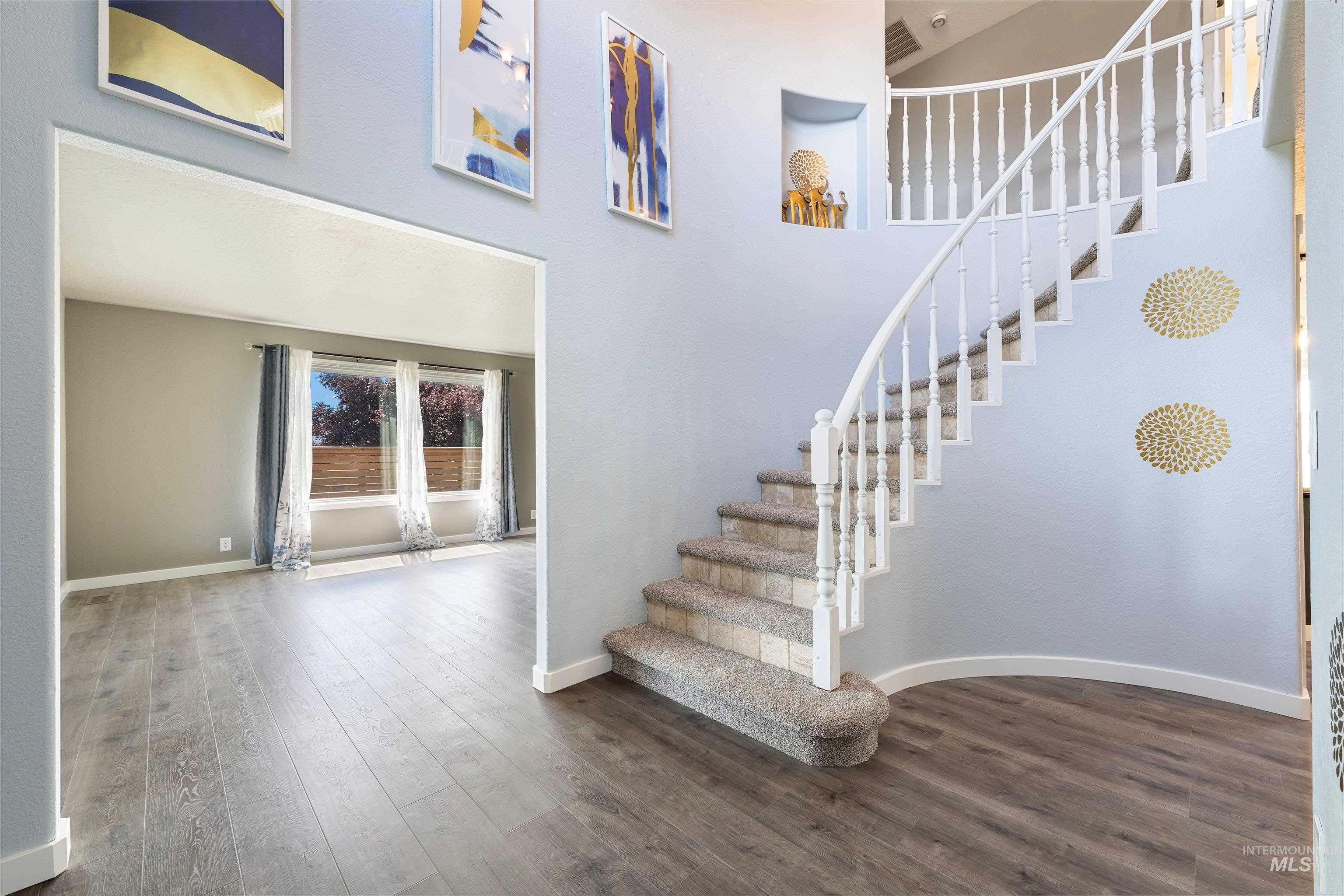 7657 Track Road Nampa, ID 83686 - Photo 5 of 49 Grand entry featuring a curved staircase with carpeted treads and white wood balusters