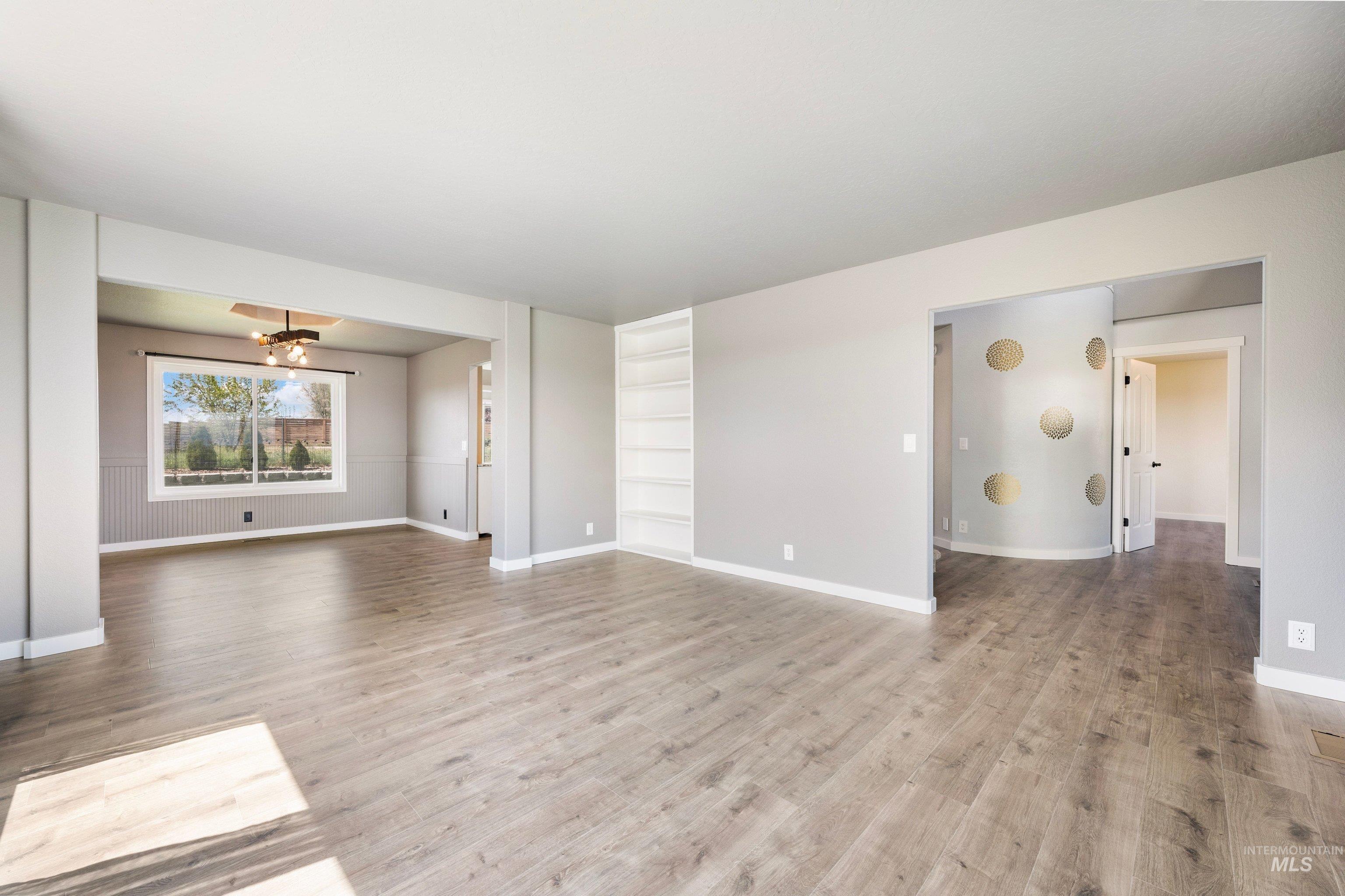 7657 Track Road Nampa, ID 83686 - Photo 7 of 49 Spacious interior featuring wood-finish flooring, recessed built-in shelving, and light gray wall tones