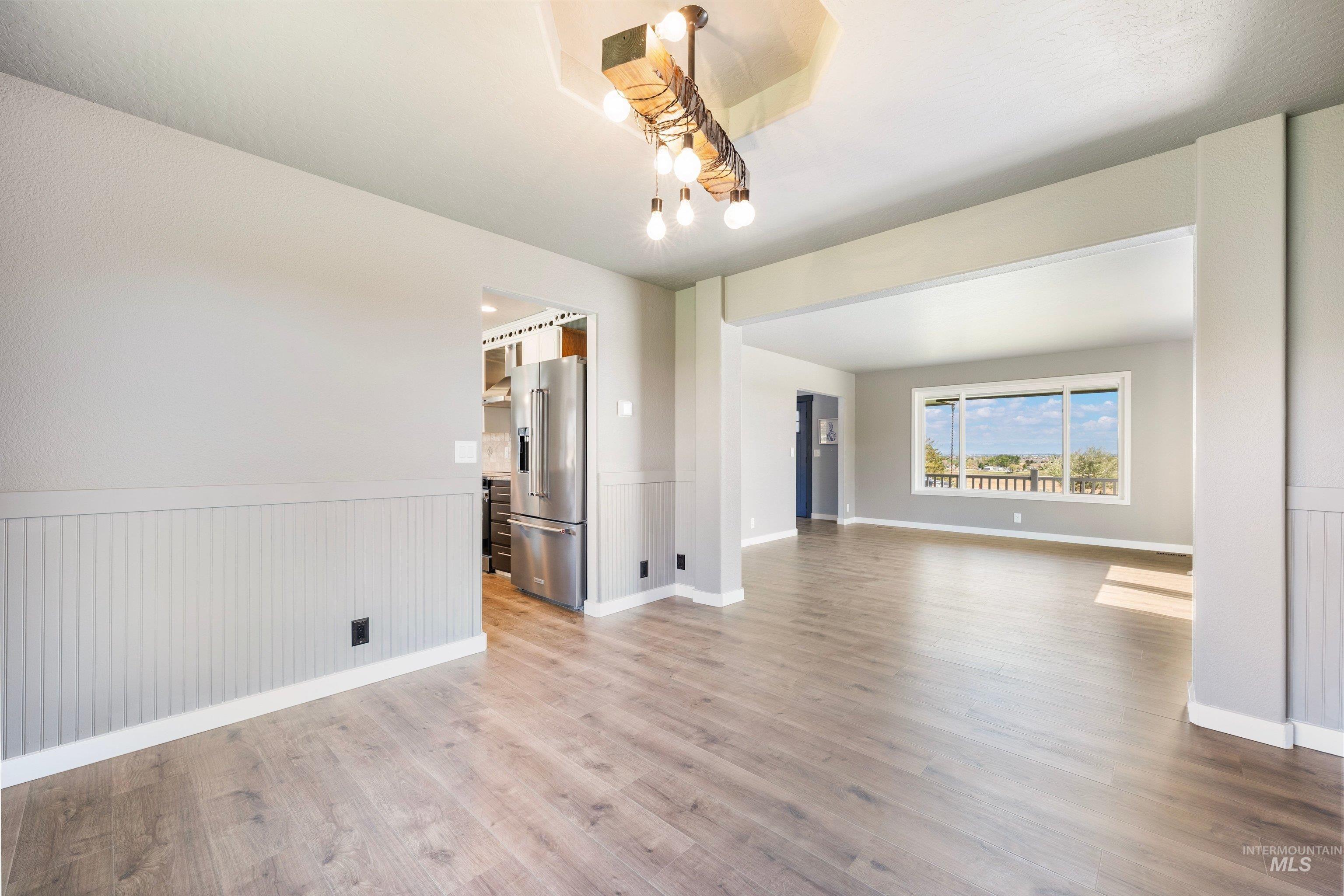 7657 Track Road Nampa, ID 83686 - Photo 8 of 49 Open-concept living area featuring wood-finish flooring, recessed ceilings, wainscoting, and a linear chandelier