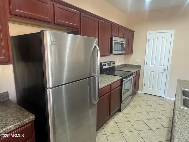 a kitchen with stainless steel appliances granite countertop a refrigerator a stove a sink and a refrigerator