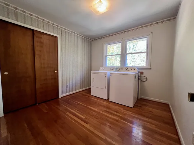 a view of a kitchen with wooden floor and white walls