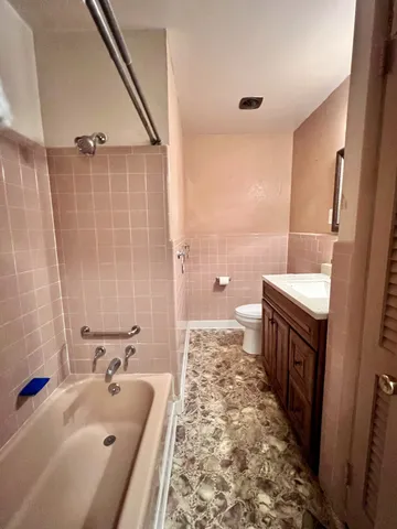 a bathroom with a tub sink and mirror