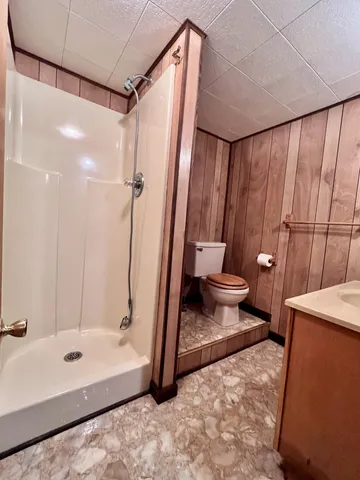 a bathroom with a sink a toilet and shower