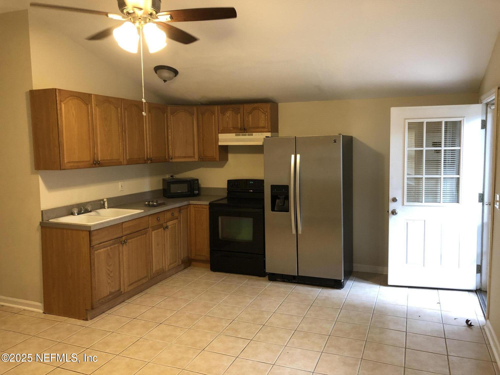 1252 Donald Street, Unit C Jacksonville, FL 32205 - Photo 6 of 7 a kitchen with stainless steel appliances granite countertop a refrigerator a sink a stove a microwave and island
