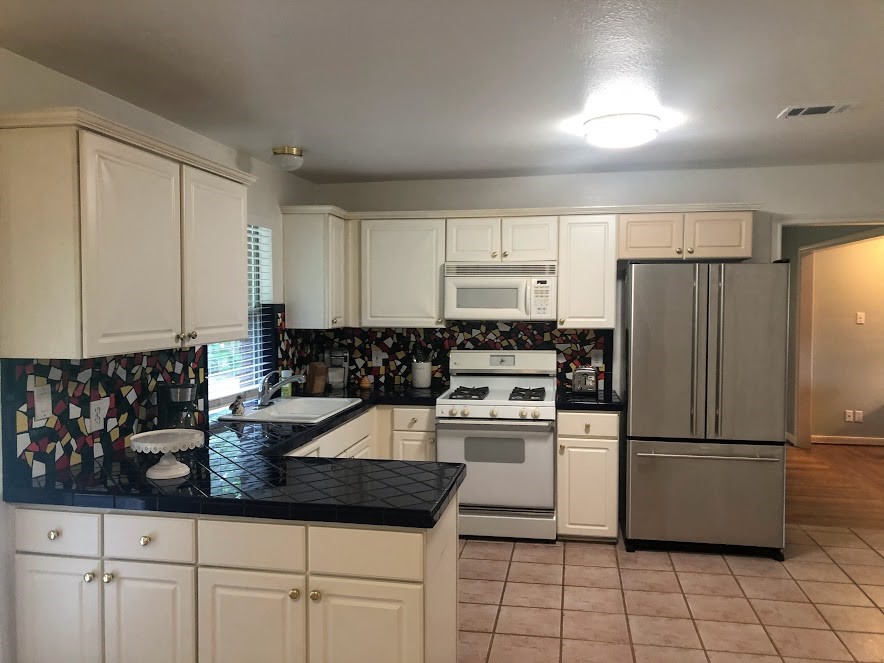 9626 Long Branch Lane Houston, TX 77055 - Photo 4 of 18 a kitchen with granite countertop a refrigerator sink and white cabinets