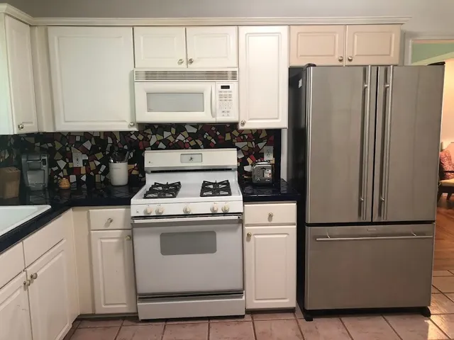 a kitchen with appliances a refrigerator and a sink
