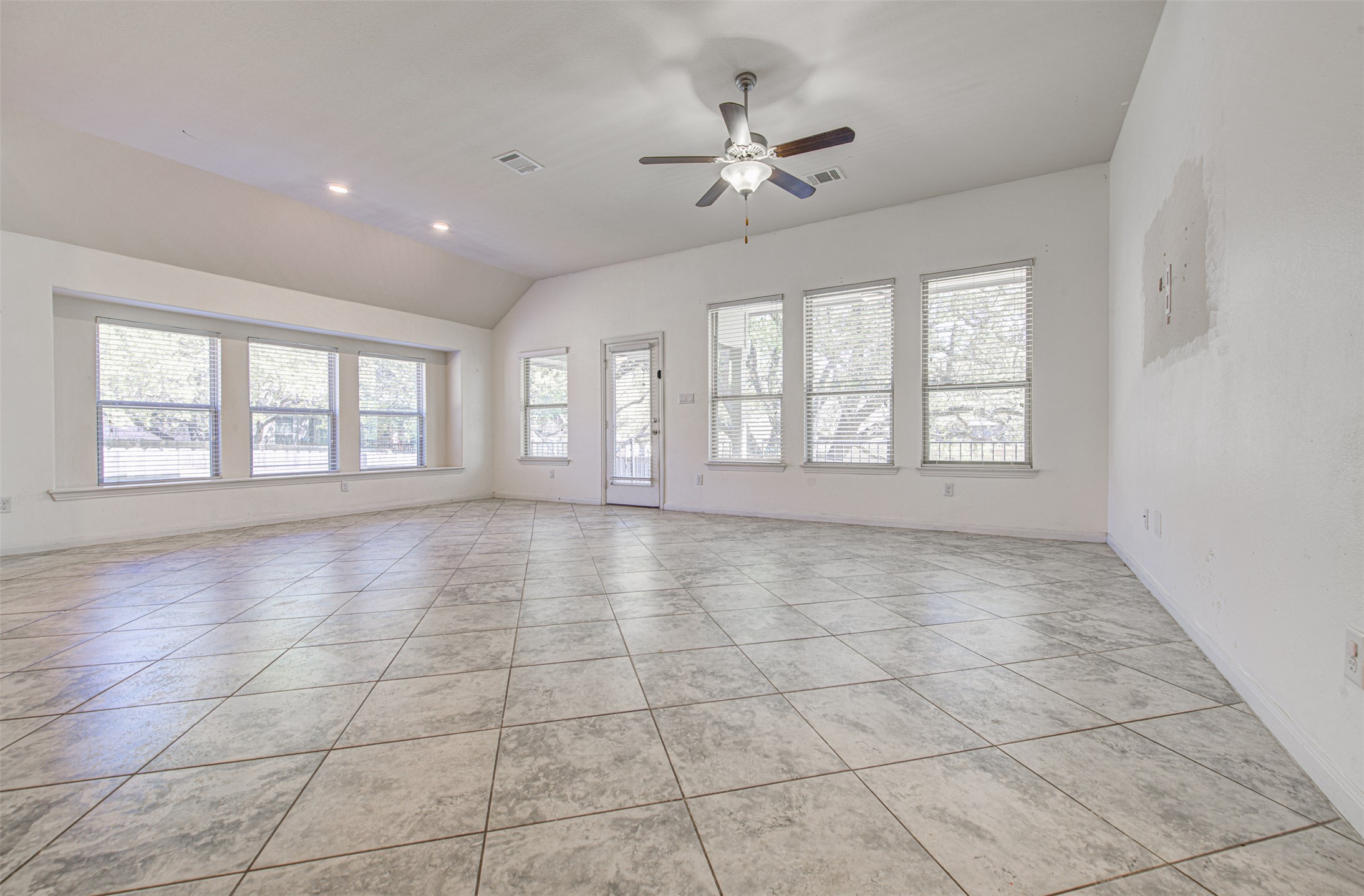 413 Pinnacle View Drive Georgetown, TX 78628 - Photo 20 of 31 Unfurnished room with ceiling fan, lofted ceiling, light tile patterned flooring, and recessed lighting
