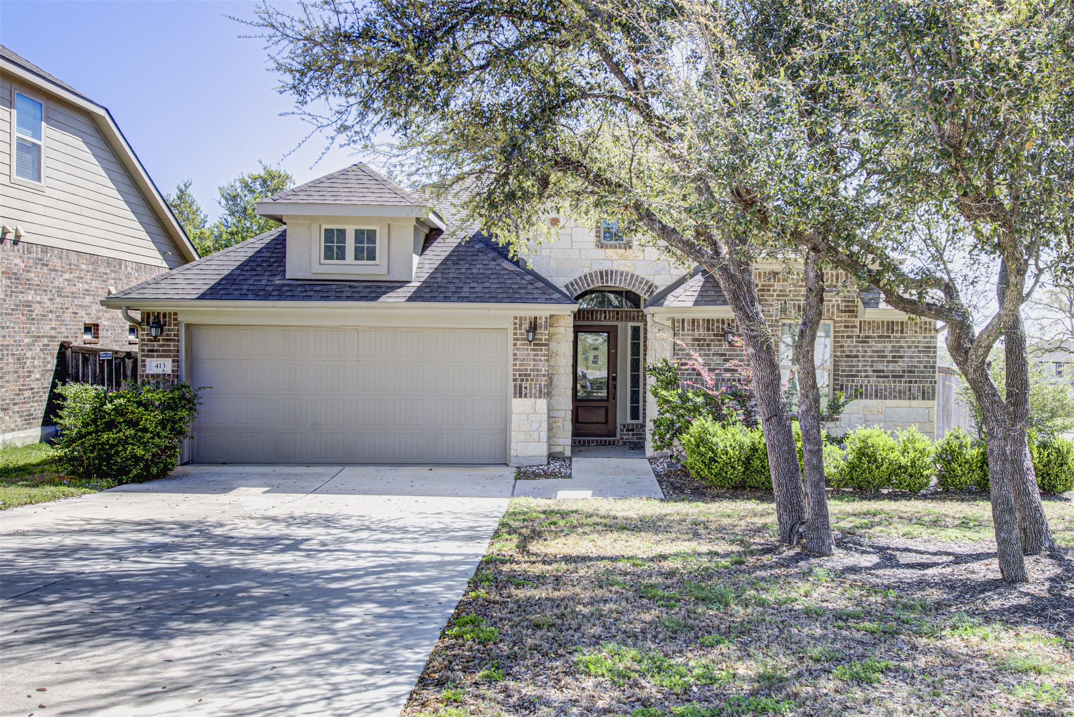 413 Pinnacle View Drive Georgetown, TX 78628 - Photo 2 of 31 French provincial home with roof with shingles, stone siding, concrete driveway, and brick siding
