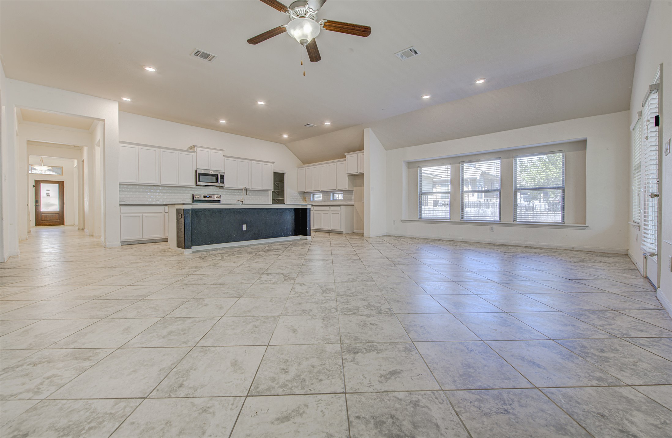 413 Pinnacle View Drive Georgetown, TX 78628 - Photo 21 of 31 Unfurnished living room featuring a ceiling fan, recessed lighting, vaulted ceiling, and light tile patterned floors