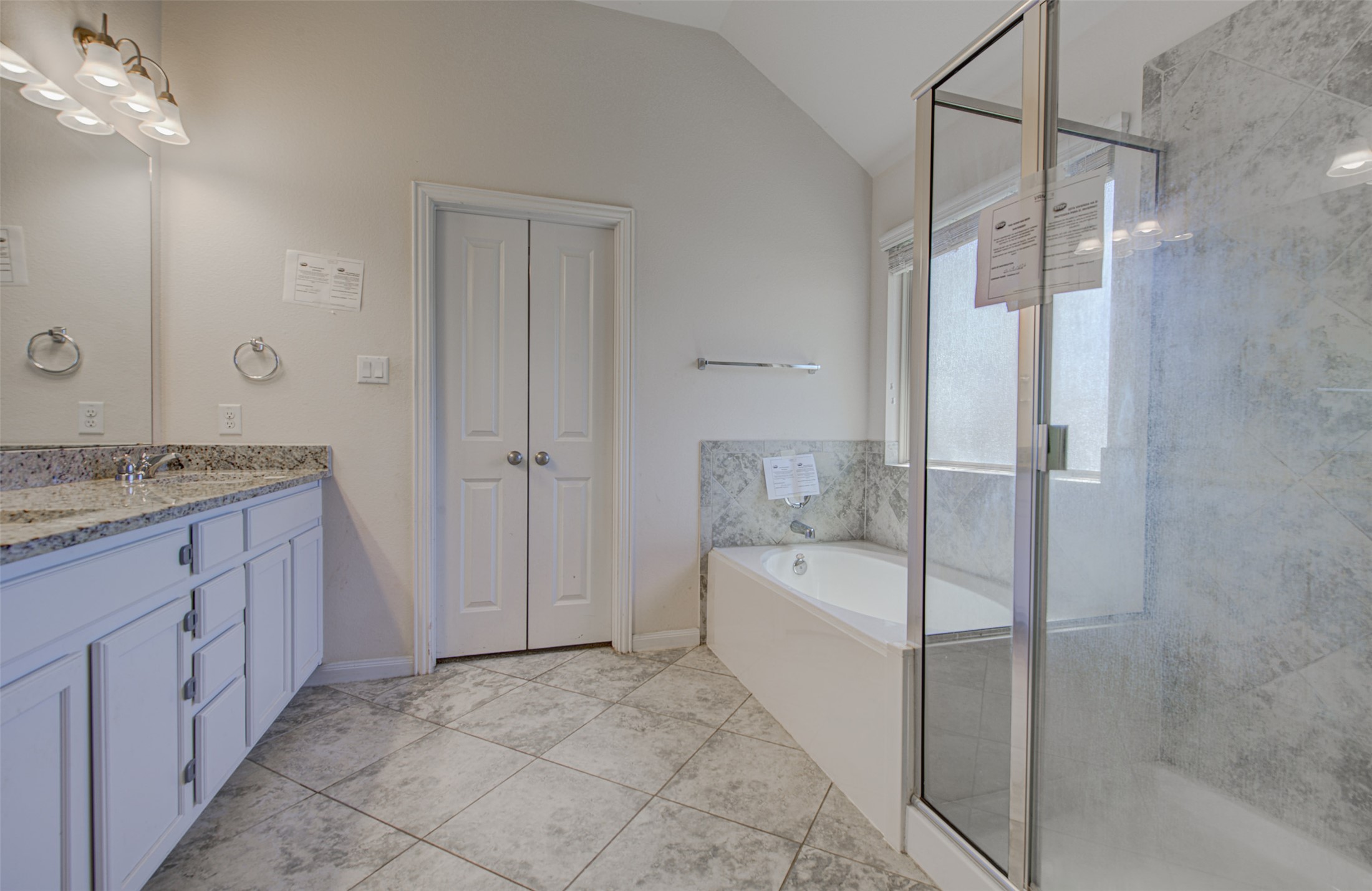 413 Pinnacle View Drive Georgetown, TX 78628 - Photo 25 of 31 Bathroom featuring double vanity, a garden tub, a shower stall, lofted ceiling, and light tile patterned flooring