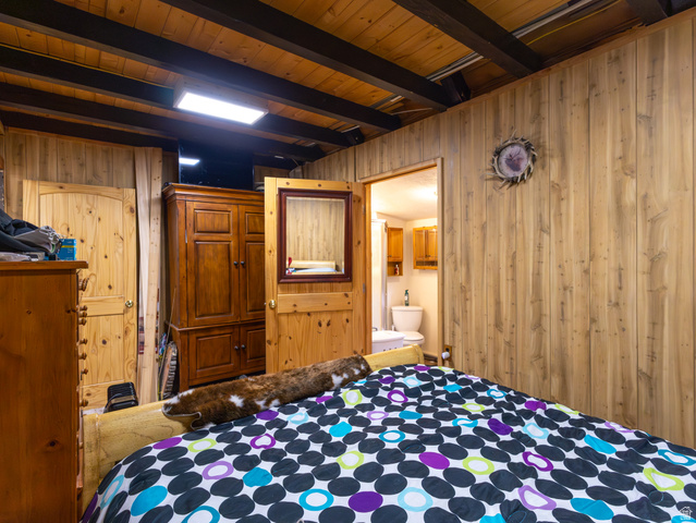 5082 Pine Crest Road Evanston, UT 82930 - Photo 17 of 25 Wood-paneled room featuring exposed wood ceiling beams and a rectangular flush-mount light fixture