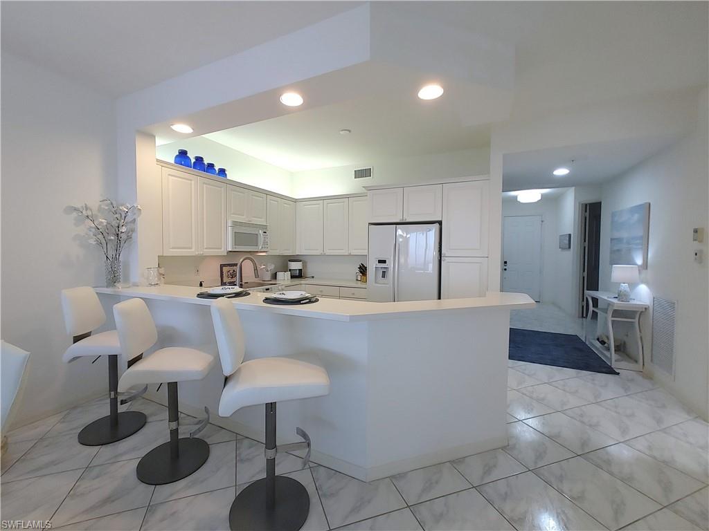 400 Flagship Drive, Unit 704 Naples, FL 34108 - Photo 8 of 28 a living room with furniture and a table