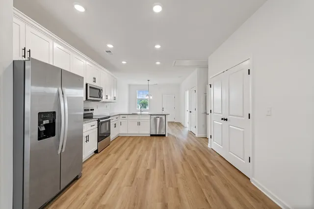 a kitchen with stainless steel appliances a refrigerator sink and cabinets
