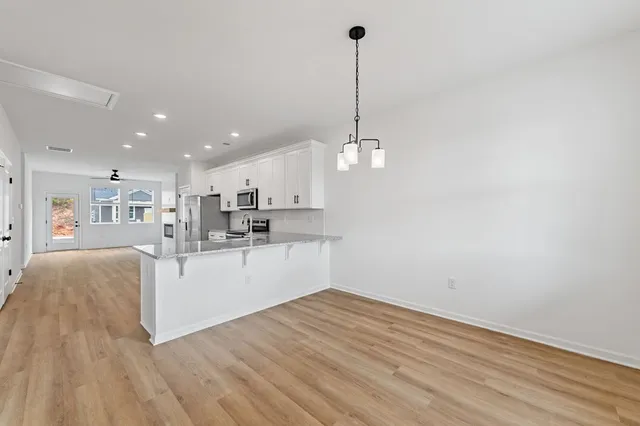a view of kitchen with refrigerator microwave and stove