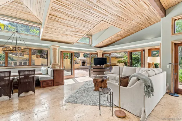 a living room with fireplace furniture and large windows