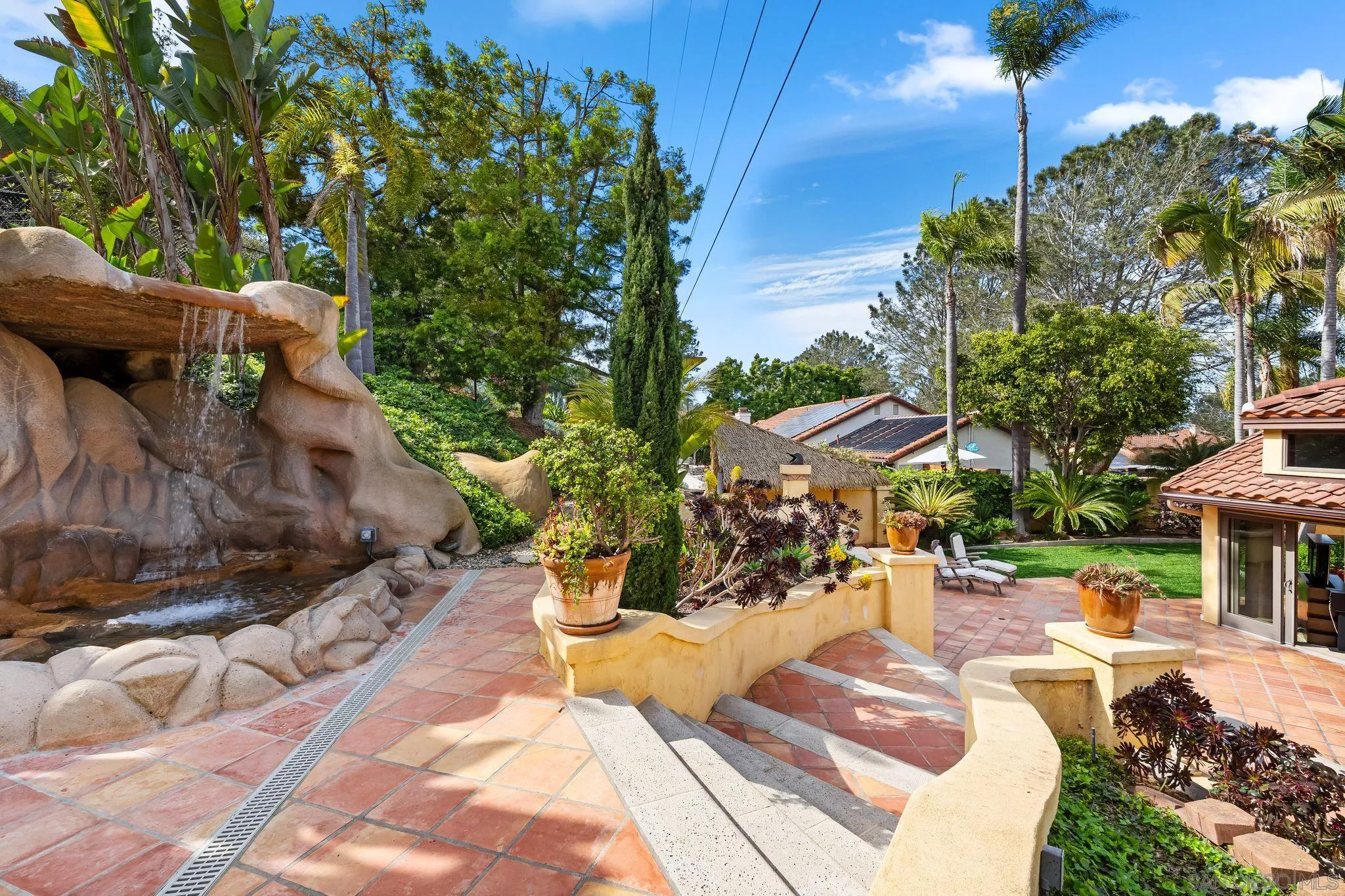 2969 Racetrack View Drive Del Mar, CA 92014 - Photo 56 of 74 a view of a patio with table and chairs potted plants and large tree