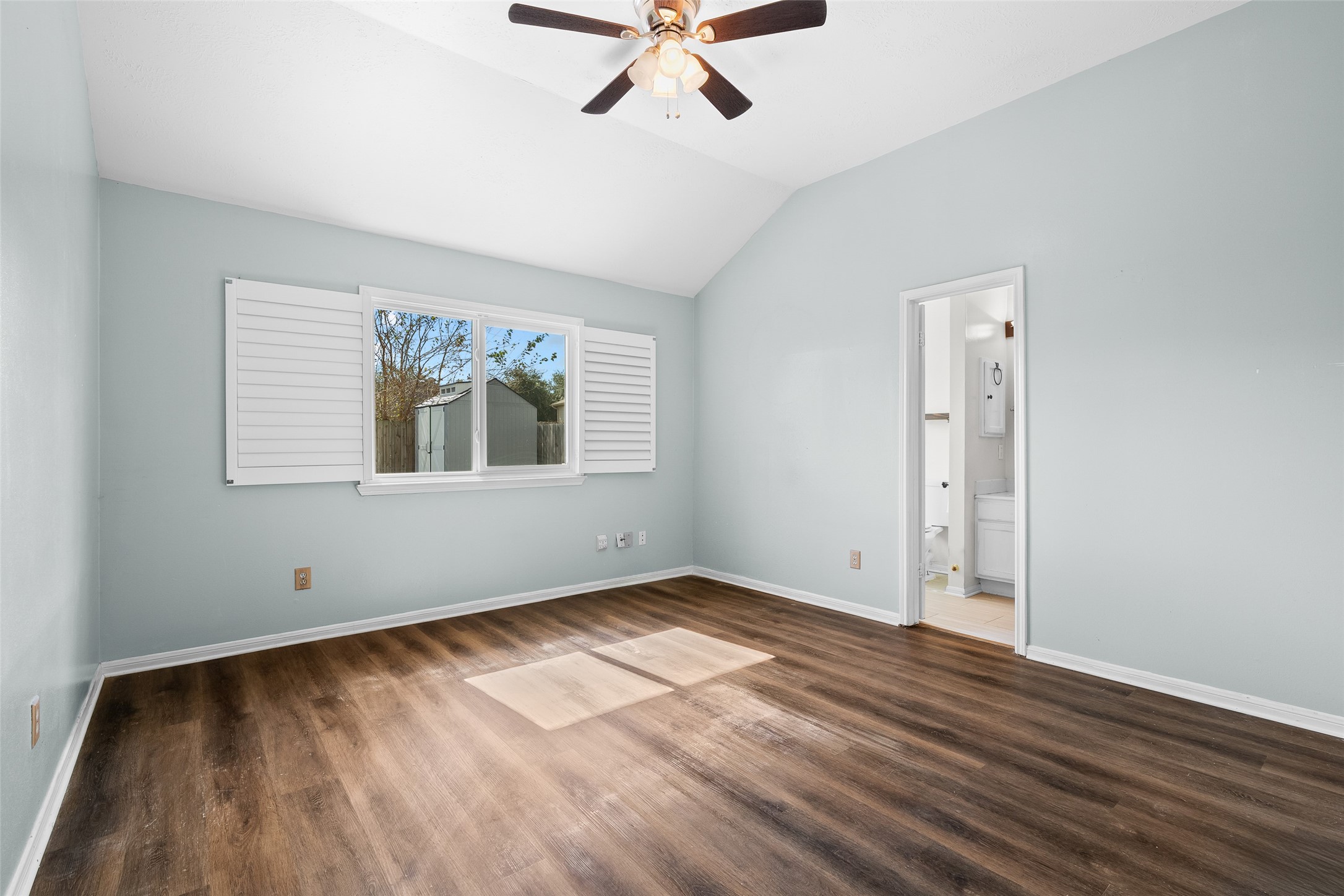 4826 Stonebridge Street Baytown, TX 77521 - Photo 5 of 18 Relax in the spacious primary bedroom, featuring beautiful vinyl plank flooring, a large window, and a ceiling fan — creating a bright, comfortable, and elegant space designed for rest and relaxation.