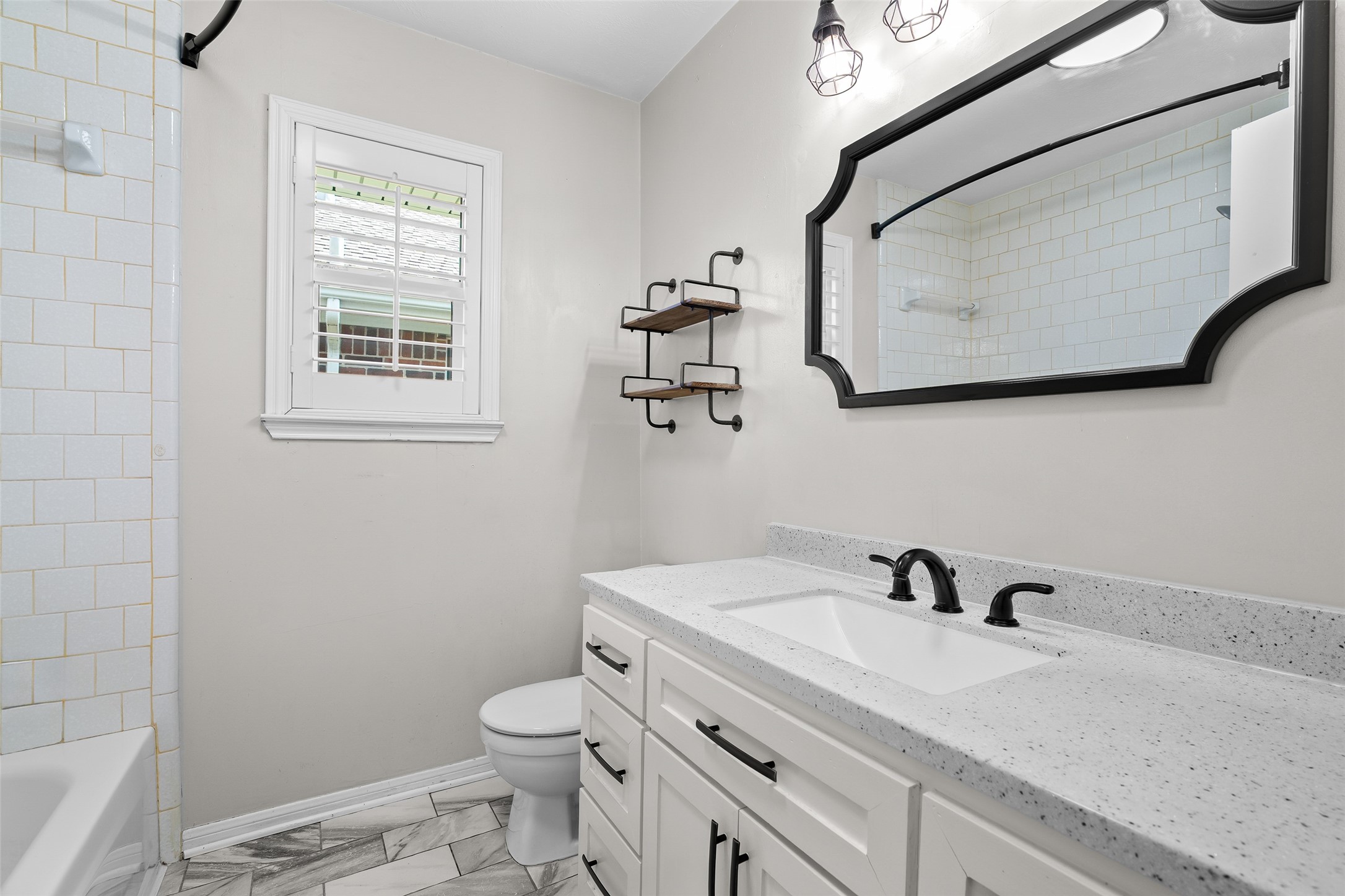 4826 Stonebridge Street Baytown, TX 77521 - Photo 9 of 18 This bathroom features a single-sink vanity, a shower/tub combo, and a toilet — a practical and stylish space designed for everyday comfort.
