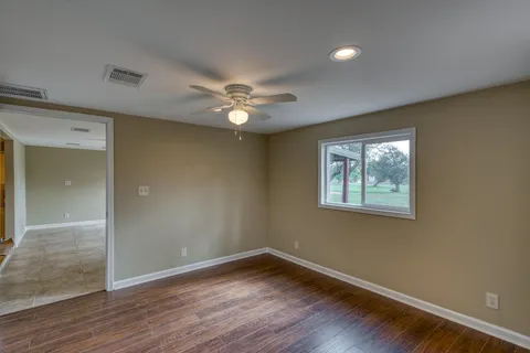 an empty room with a ceiling fan and a window