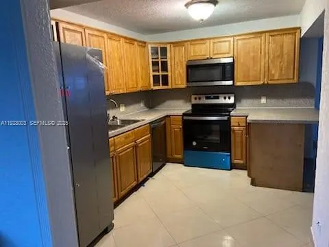 a kitchen with sink a microwave and cabinets