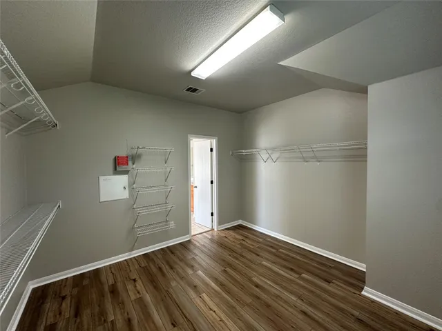 a view of empty room with wooden floor