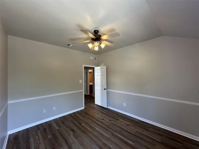 a view of an empty room with a window and a ceiling fan