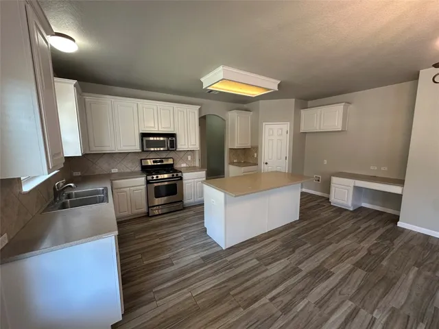 a kitchen with wooden floors and wooden cabinets